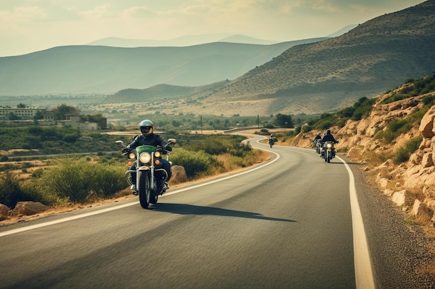 Photo two motorcyclists ride down a winding road with mountains in the background.