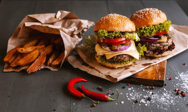 Two mouth-watering, delicious homemade burger used to chop beef. on the wooden table.