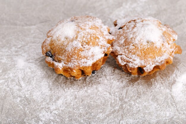 Two muffins sprinkled with powdered sugar. View from above. Copy space.