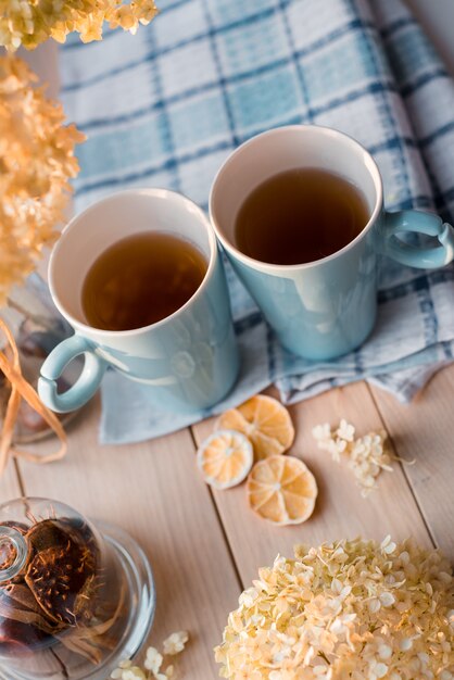 Two mugs of hot tea on a linen blue napkin