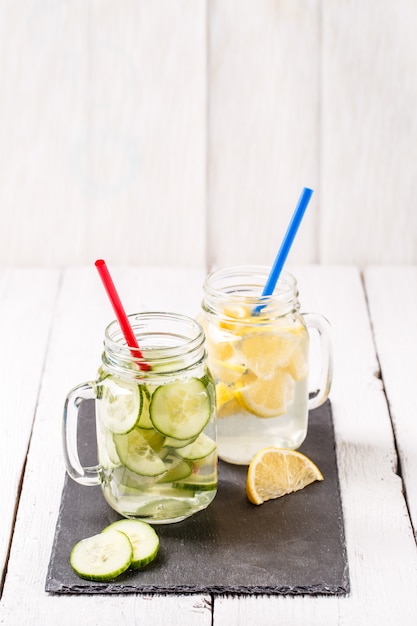 Two mugs of infused detox diet refreshing waters: with cucumber and lemon