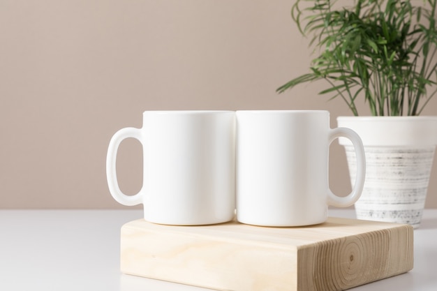Two mugs mockup on beige table Front view