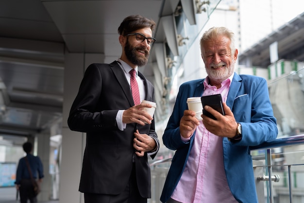 Two multi ethnic bearded businessmen together around the city