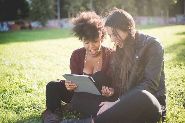 two multi-ethnic beautiful young women using tablet