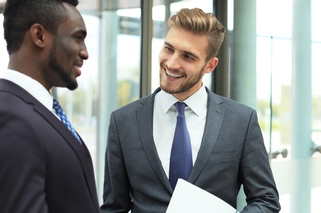 two multinational young businessmen discussing business at meeting in office.