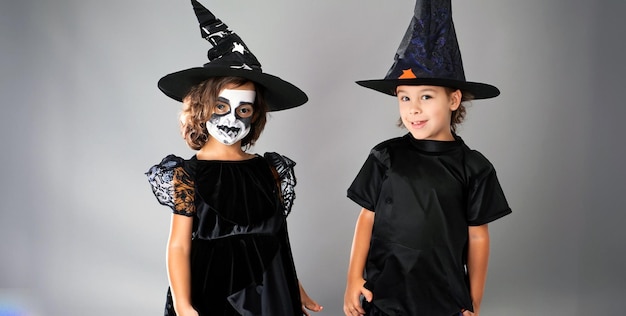 Two multiracial kids in scary costumes posing for Halloween festival event