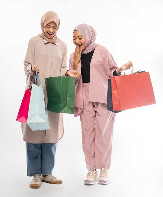 Two muslim friend suprised while looking inside the shopping bag