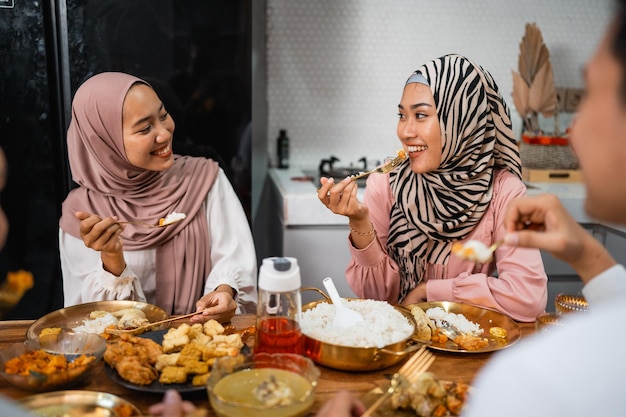 Two muslim girl friend chatting while having iftar dinner at home