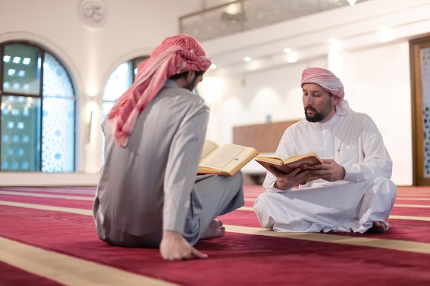 two muslim people in mosque reading quran together concept of islamic education and school of holly book kuran