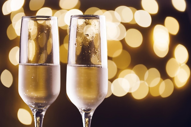 Два новогодних бокала шампанского с акцентами на цветном фоне копирования пространства