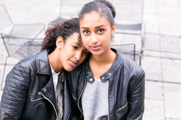 Two north African teen friends sitting together talking