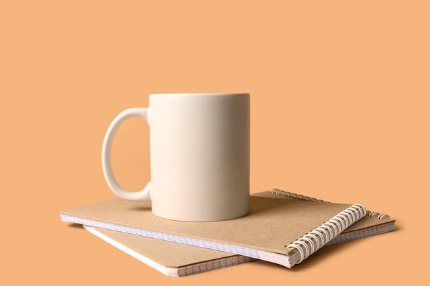 Two notebooks and a ceramic white mug Minimalistic layout for design The concept of work at home