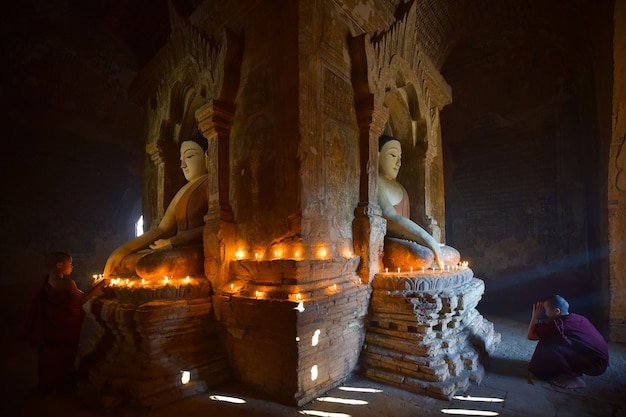 Two novice light candle and pray in bagan pagoda in myanmar