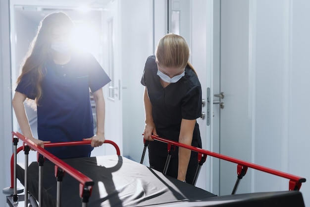 Two nurses roll an empty hospital gurney down the corridor Emergency call