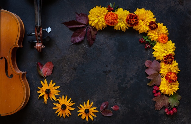 2つの古いバイオリンと明るい秋の花のパターン