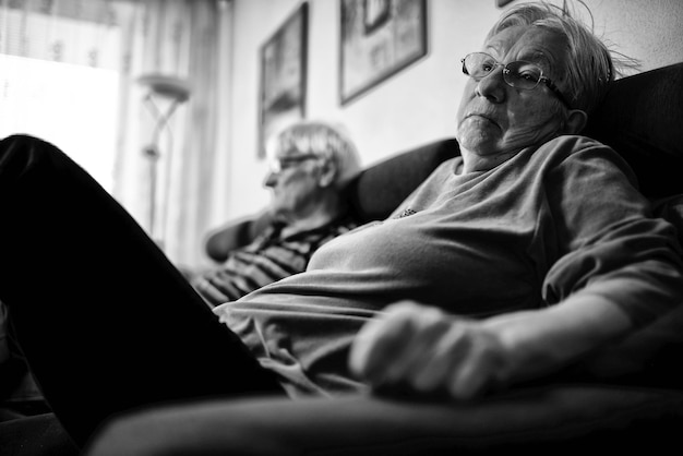 Photo two older people sit on a couch