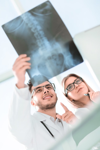 Два врача-ортопеда смотрят на рентгеновский снимок пациента