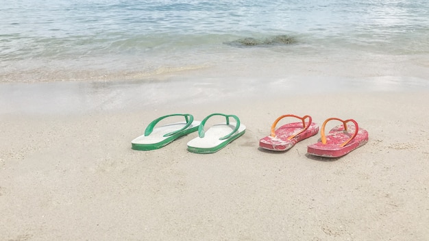 Photo two pairs of casual shoes are placed on the beach, offering a holiday concept