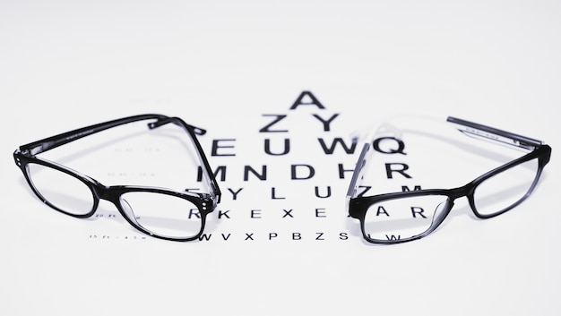 Two pairs of glasses on the table for vision check in black and white