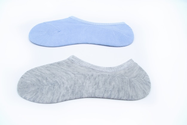 Two pairs of new short socks of blue and gray color are lying on a white background