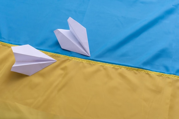 Two paper airplanes with the flag of Ukraine. Handmade arts concept