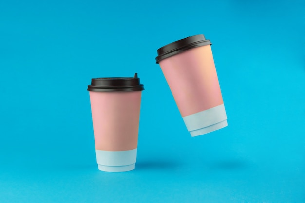 Photo two paper coffee cups on a blue background