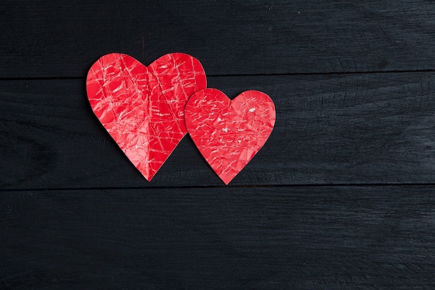 Two paper hearts over wooden surface. Valentine background