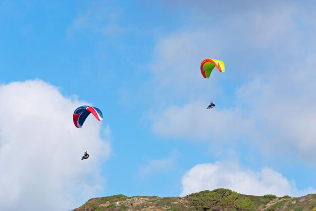 Two para gliders flying on a cloudy day