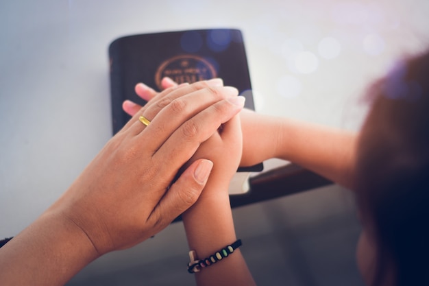 Two people are holding hands and pray together