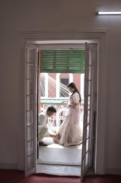 two people are looking out of a window with a woman in a dress