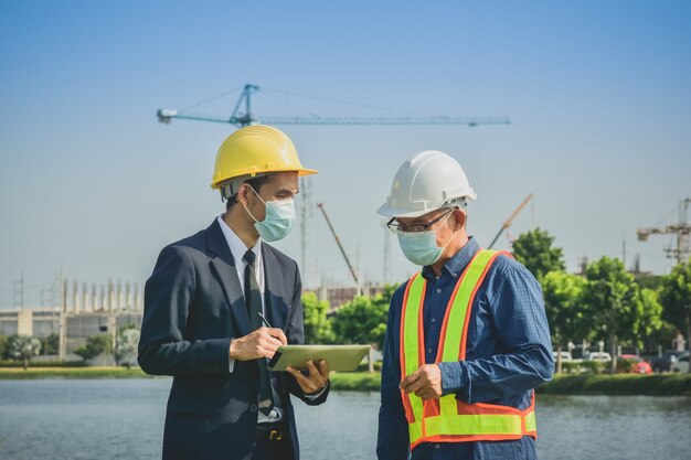 Two people Businessman talking with senior on site construction about real estate plant project and Business project