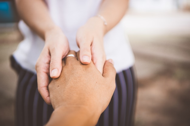 Due persone si tengono per mano per il comfort. dando una mano.