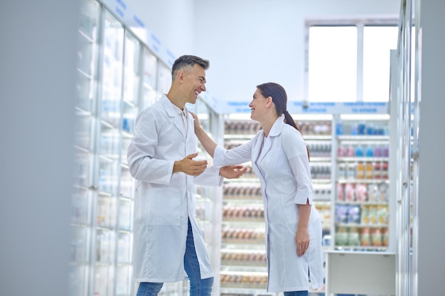 Two people in lab coats feeling good and smiling