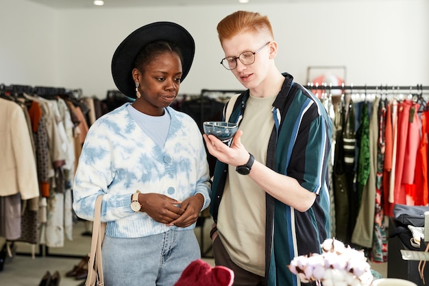 Two people looking at items in thrifting shop