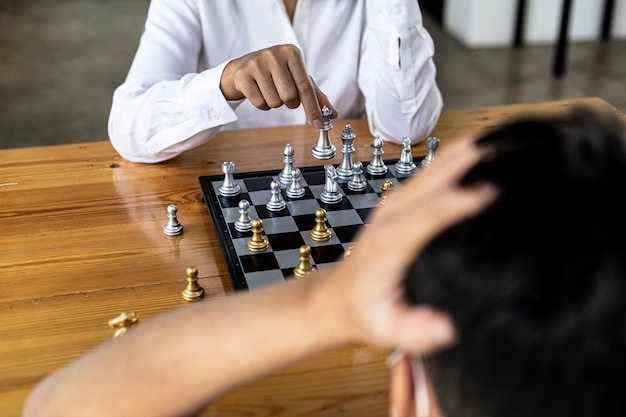 Two people playing a game of chess, concept image of two businessmen playing chess compared to a business competition that requires strategic planning and risk-based business management.