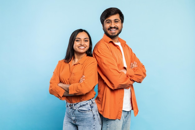 Two people posing confidently together on blue