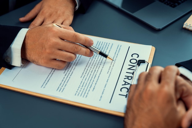 Two people signing contract on a desk