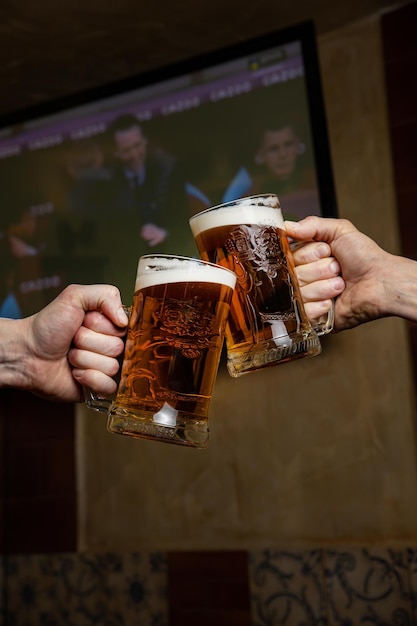 Two people toasting with a beer mug