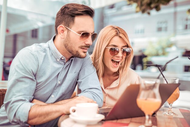 Two people using laptop in the city