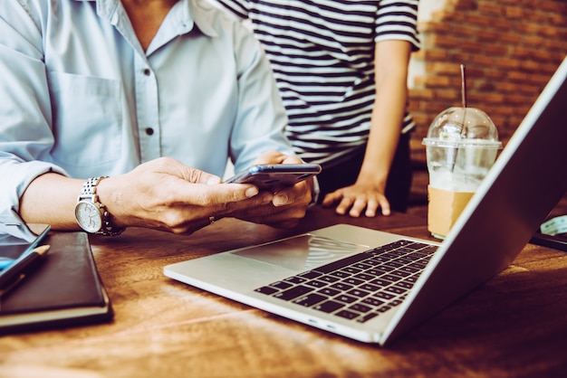 Two people using mobile while meeting in coffee shop for SMEs owner job