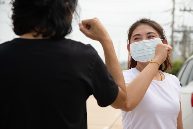 Photo two people wear facemask elbow shake hand