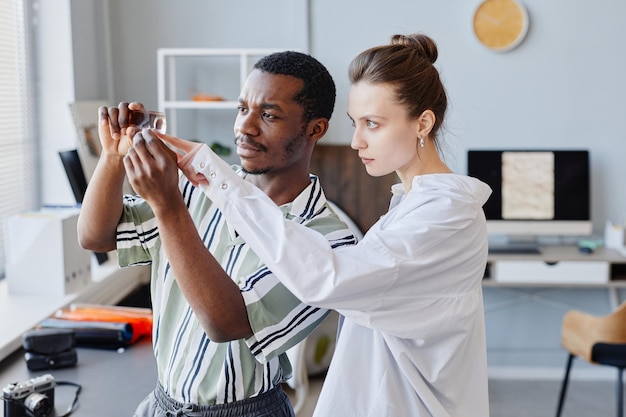 Two Photographers Looking At Film In Studio