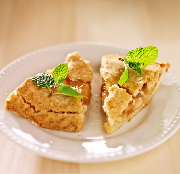 Two pieces of apple pie with mint garnish