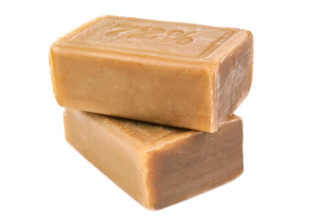 Two pieces of brown soap on white background