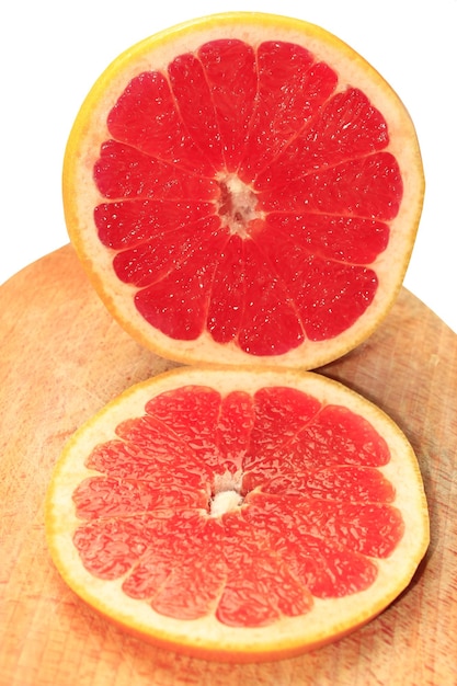 two pieces of cut grapefruit on the board isolated on the white