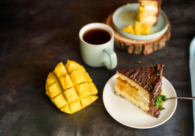 Two pieces of delicious cake with mango, a cup of fragrant tea. View from above.