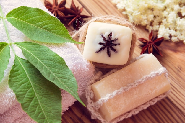 Two pieces of dry white soap with towels, anises and elder