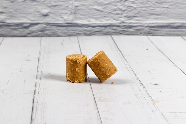 Two pieces of peanut candy on a white wooden table