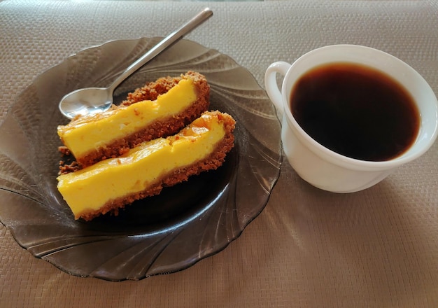 Two pieces of pie on a plate with a spoon and a cup of coffee for breakfast Top view