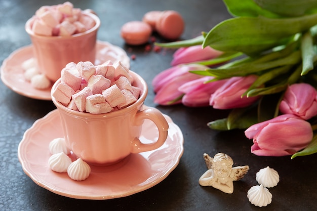 Two pink cups with pink heart shaped marshmallows